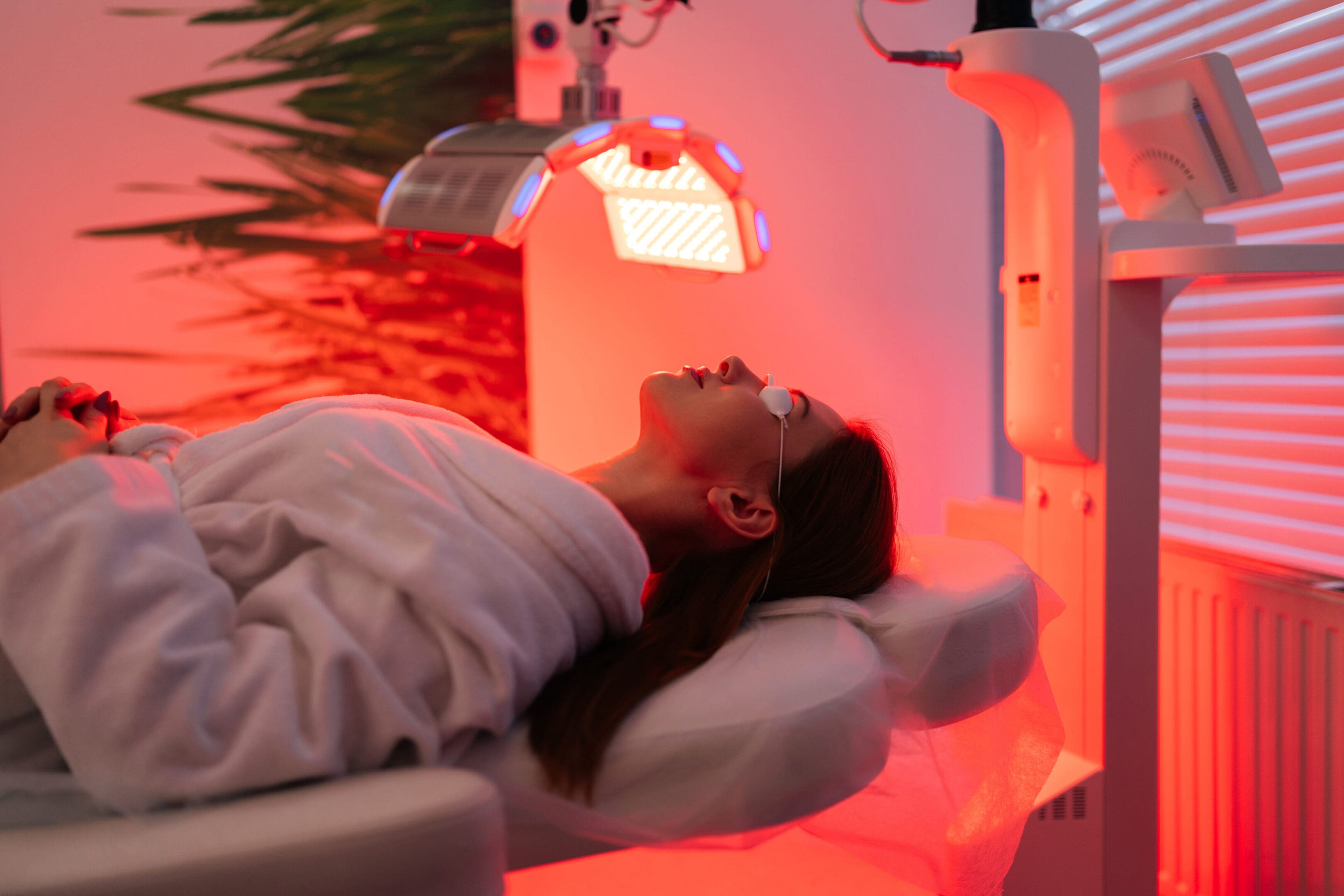 A woman laying down in the sun with red light shining on her.