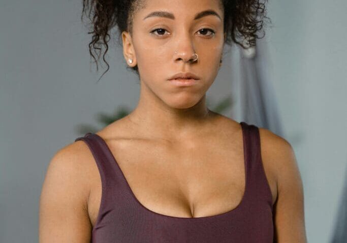 A woman with curly hair and a purple top.